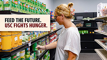 student stocking canned goods at the USC Food Pantry