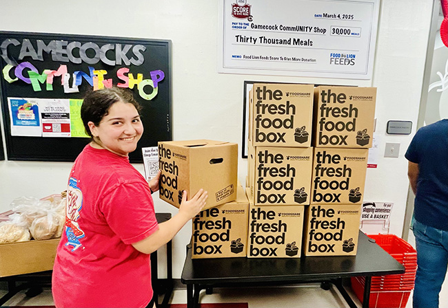 Student stacking care packages in USC Food Pantry