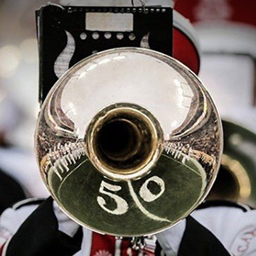 Trumpet player with 50-yard line refelected in the bell of the trumpet