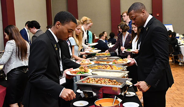 Nicely dressed people making plates at a buffet