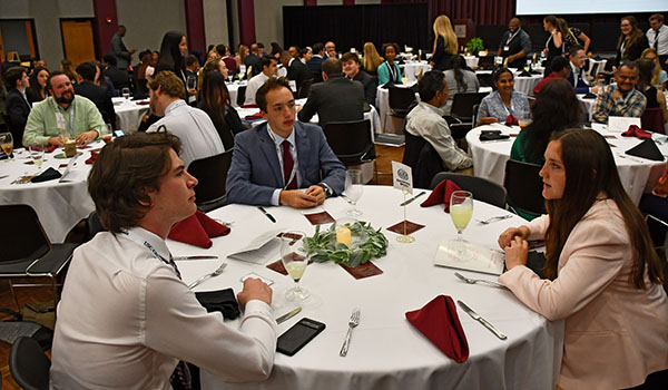 Three people conversing at a round table