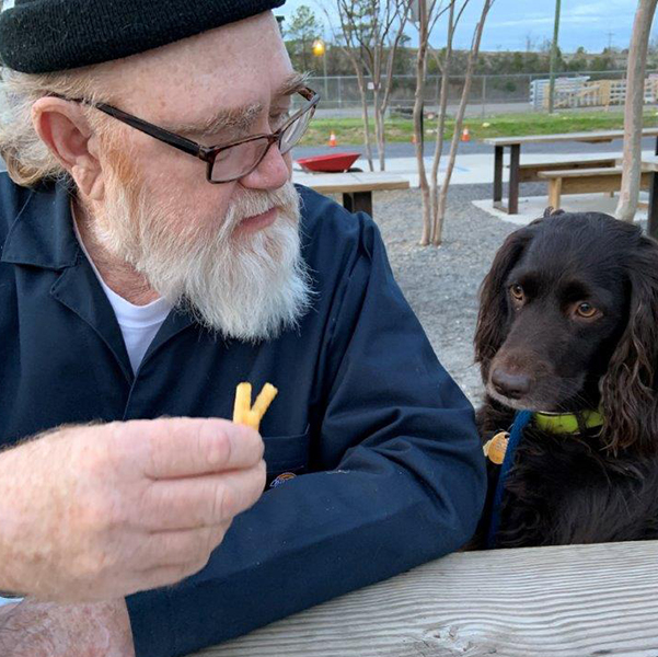 Dr Wally Peters sharing french fries with his dog