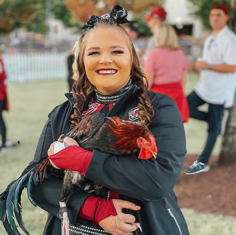 USC Cheerleader holding a rooster