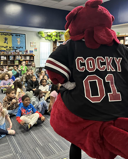 USC mascot Cocky reading to a classroom of children
