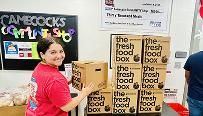 Student stacking care packages in USC Food Pantry
